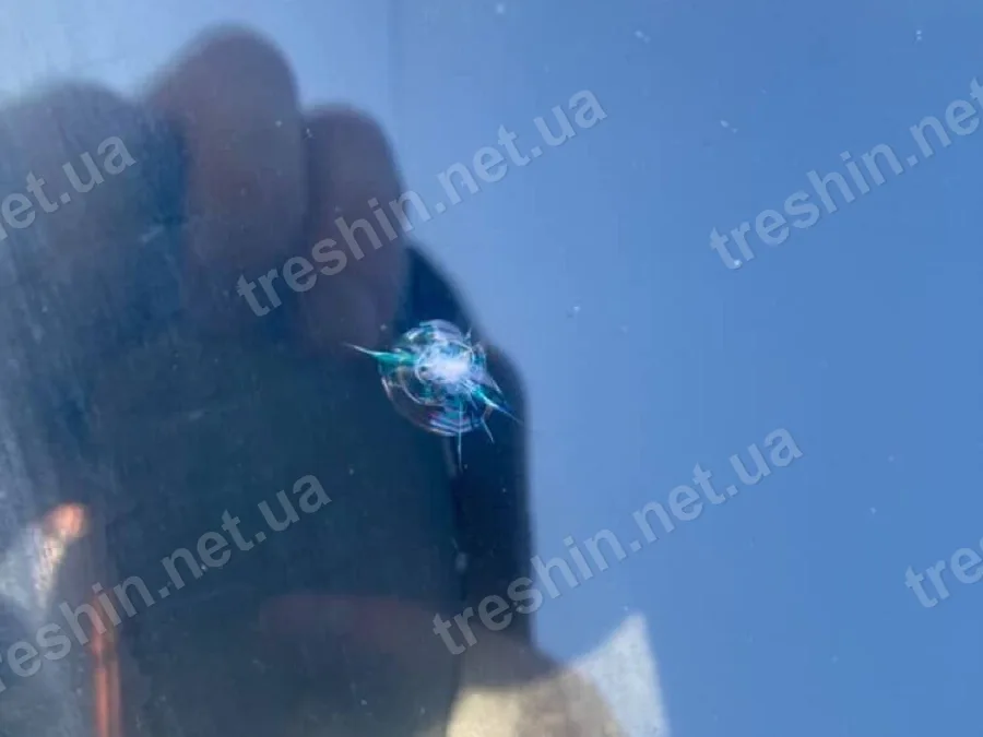 Скол на лобовом стекле, прикрытый от солнца рукой