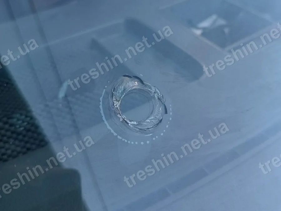 Скол на лобовом стекле крупным планом, вид из салона
